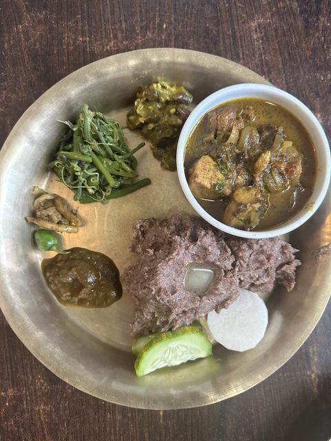 Traditional Nepali food dhindo along with chicken curry, tomato pickel, green vegetables, etc.